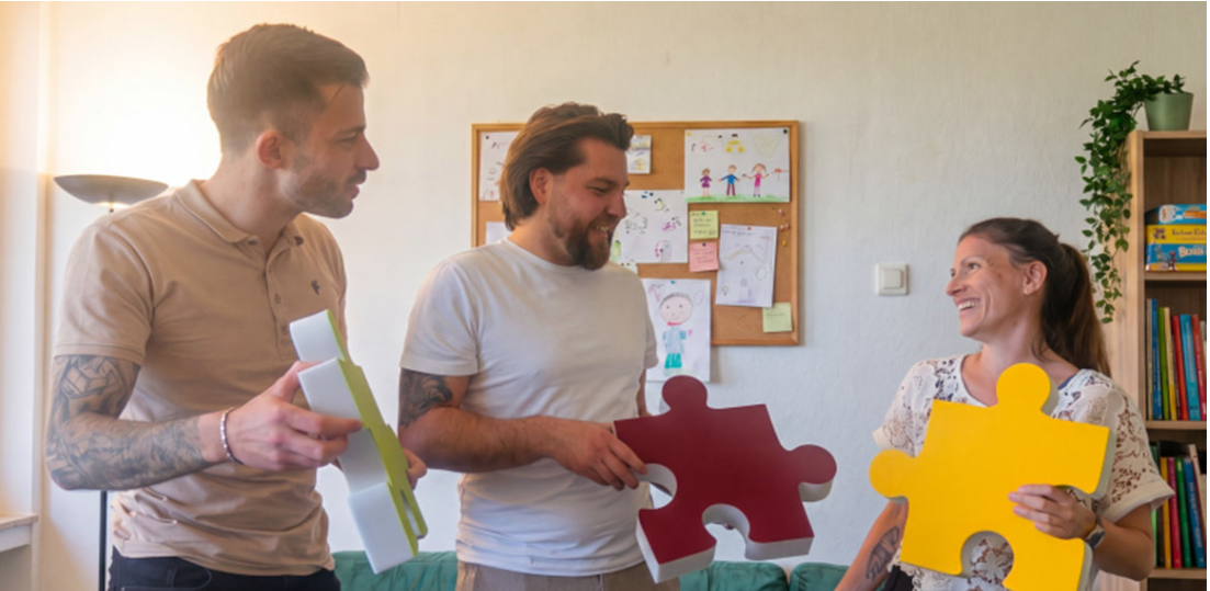 Niklas Köhn in der Mitte mit zwei weiteren Personen und großen Puzzleteilen